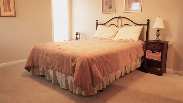 a bedroom with a bed and a night stand