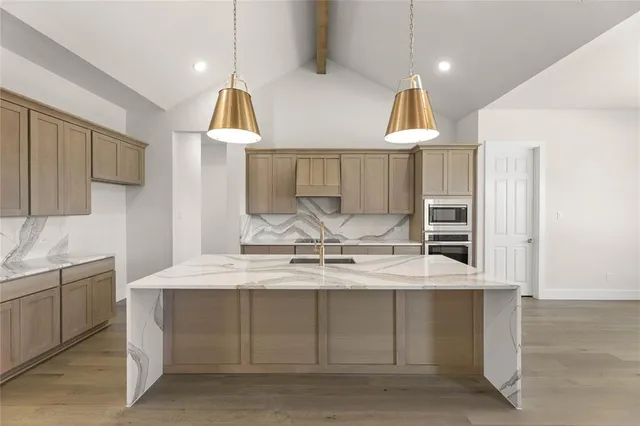 a kitchen with a sink dishwasher a stove and a refrigerator with wooden floor