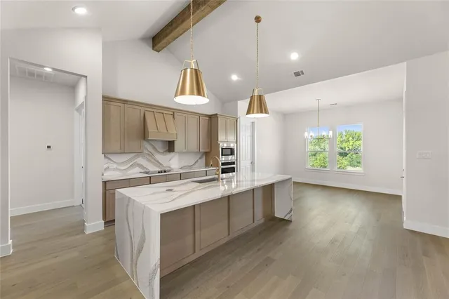 a kitchen with stainless steel appliances granite countertop sink a stove and a refrigerator