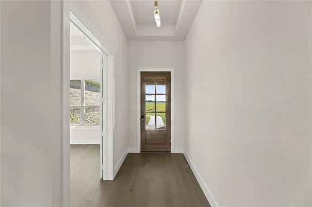 a view of a kitchen with kitchen island a sink wooden floor and stainless steel appliances