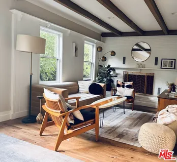 a living room with furniture a rug and a large window