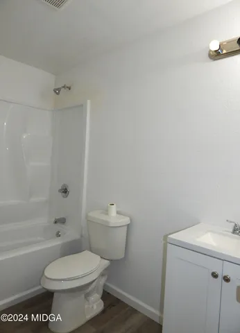 a white toilet sitting next to a bath tub