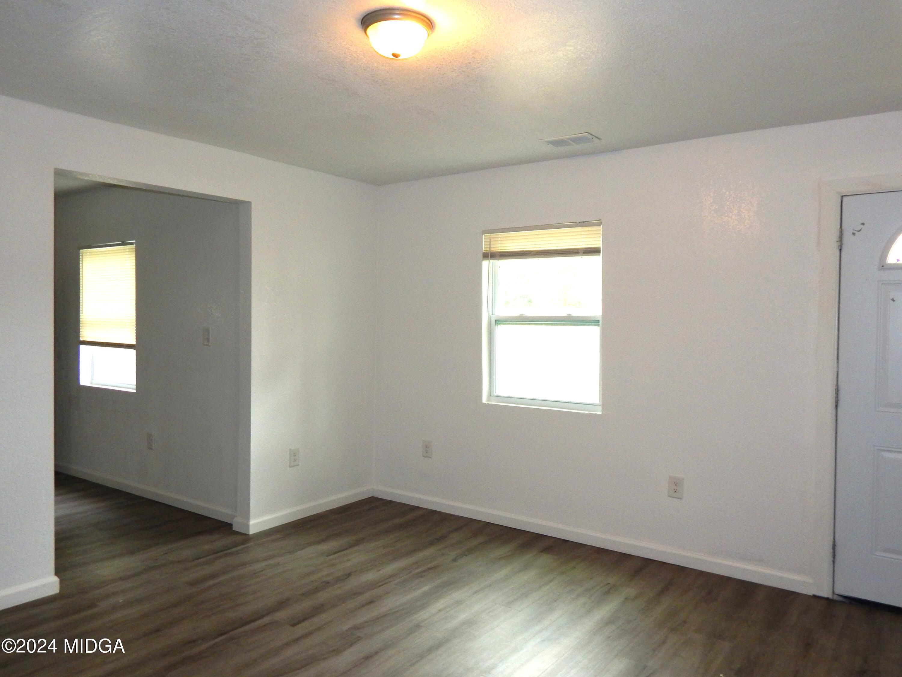 3835 Kings Park Circle Macon, GA 31217 - Photo 4 of 15 an empty room with wooden floor and windows