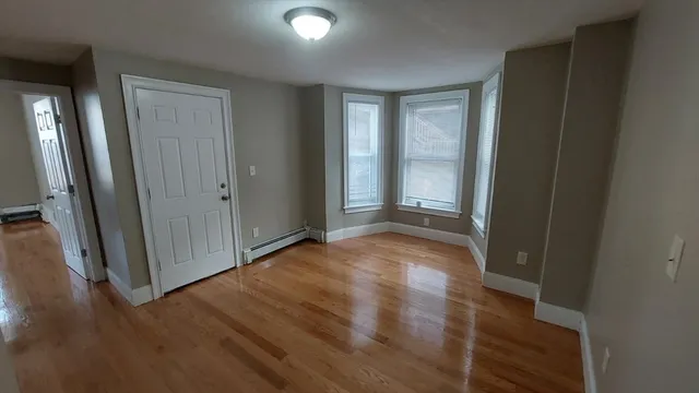 an empty room with wooden floor and a window