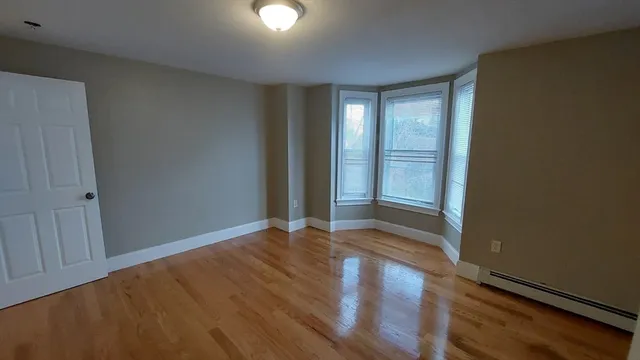 a view of an empty room with wooden floor