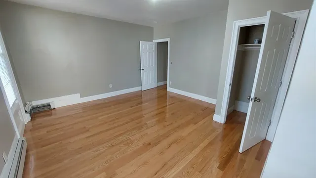 an empty room with wooden floor and closet