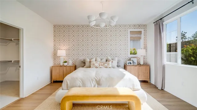 a bedroom with a bed a mirror and window