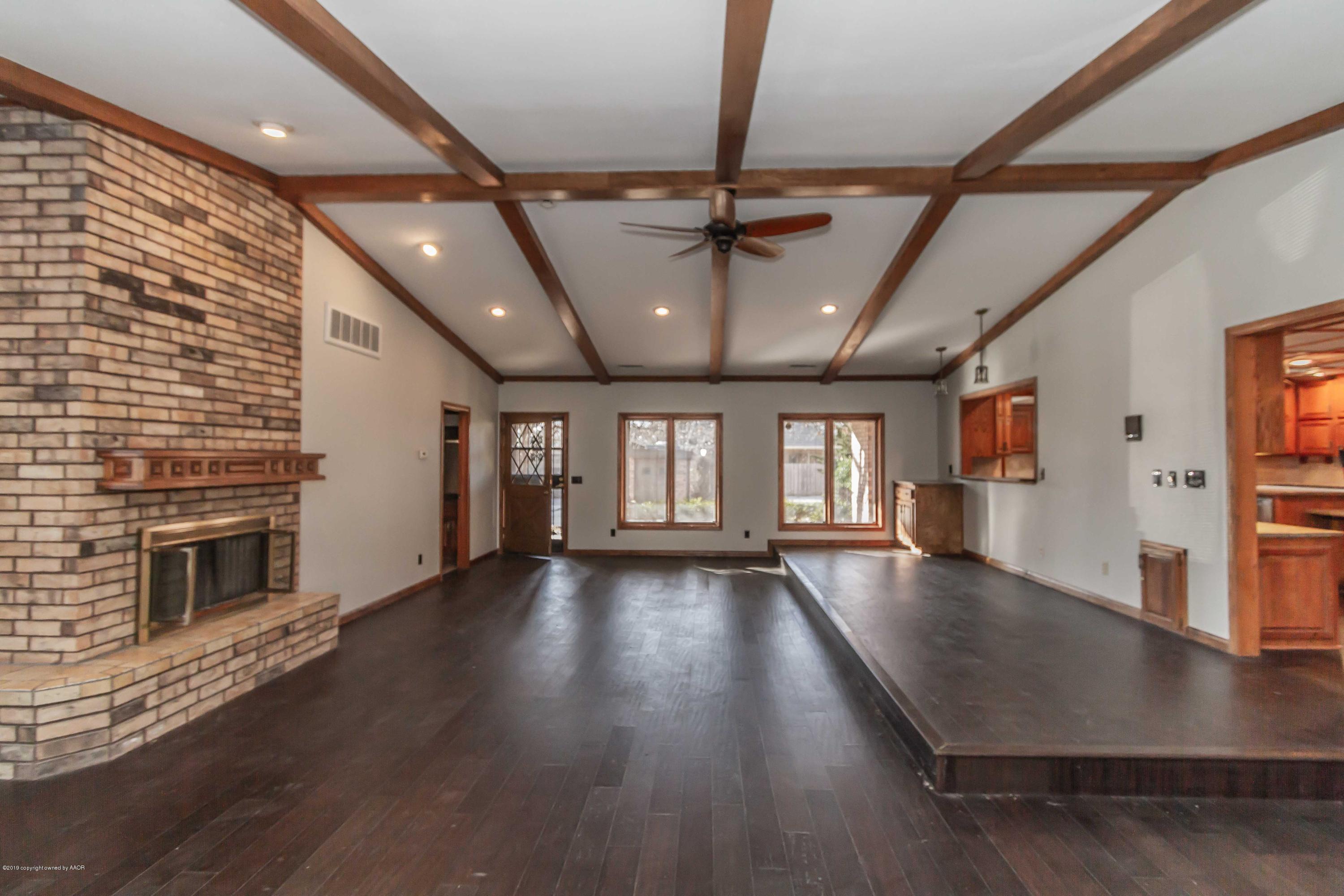 6801 Green Haven Road Amarillo, TX 79110 - Photo 18 of 65 a view of an empty room with wooden floor and a fireplace