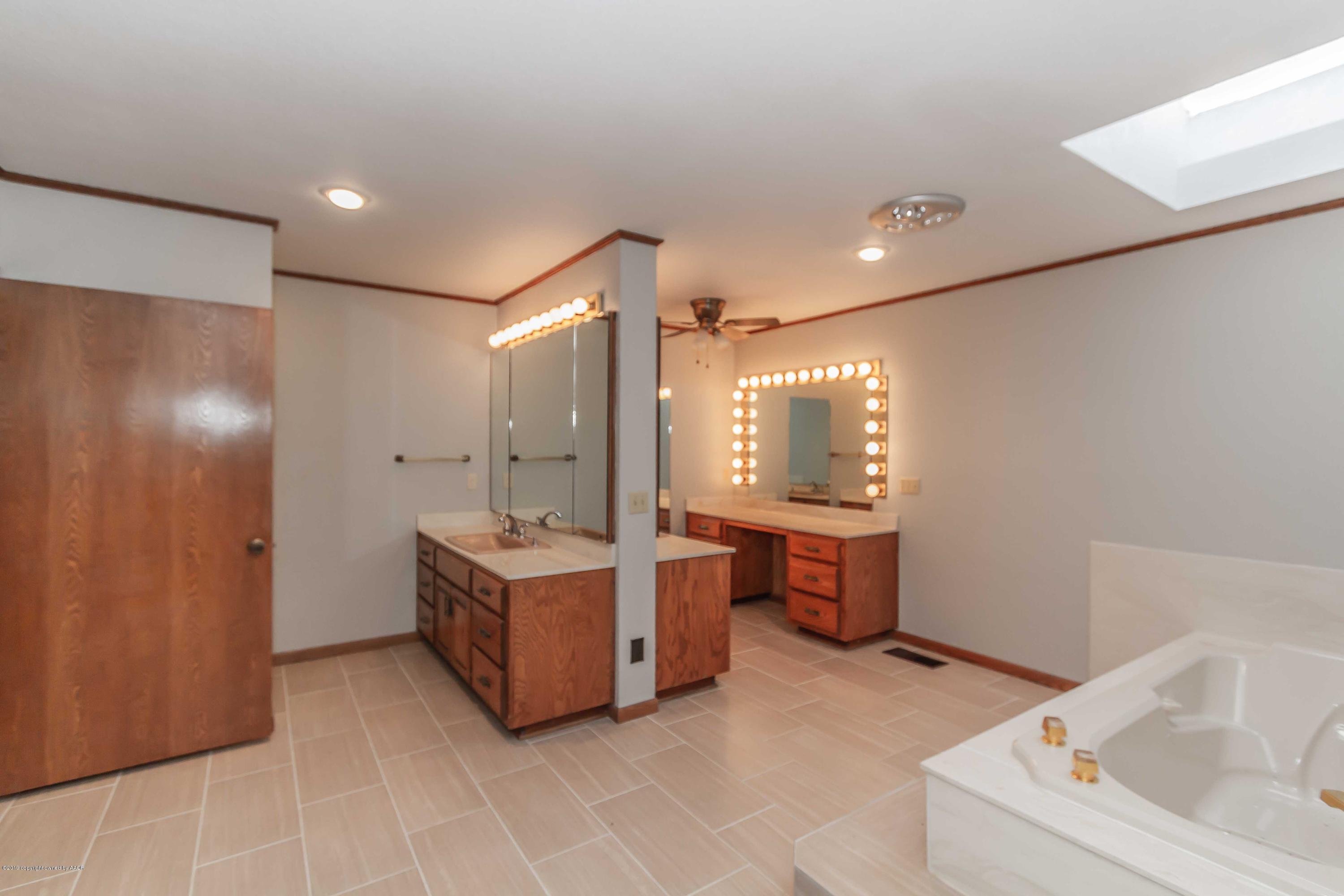 6801 Green Haven Road Amarillo, TX 79110 - Photo 22 of 65 a bathroom with a tub sink and mirror