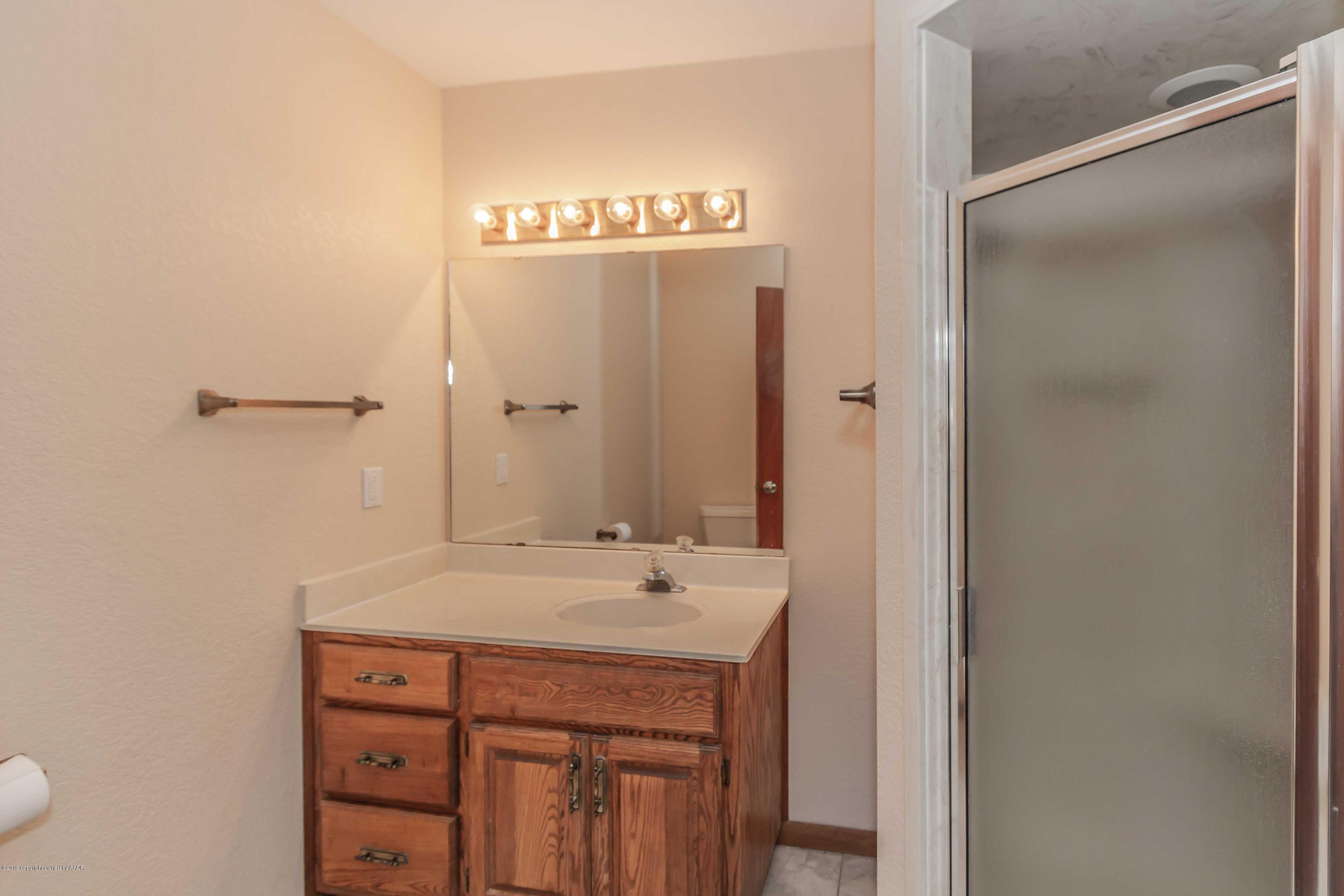 6801 Green Haven Road Amarillo, TX 79110 - Photo 32 of 65 a bathroom with a sink and a mirror