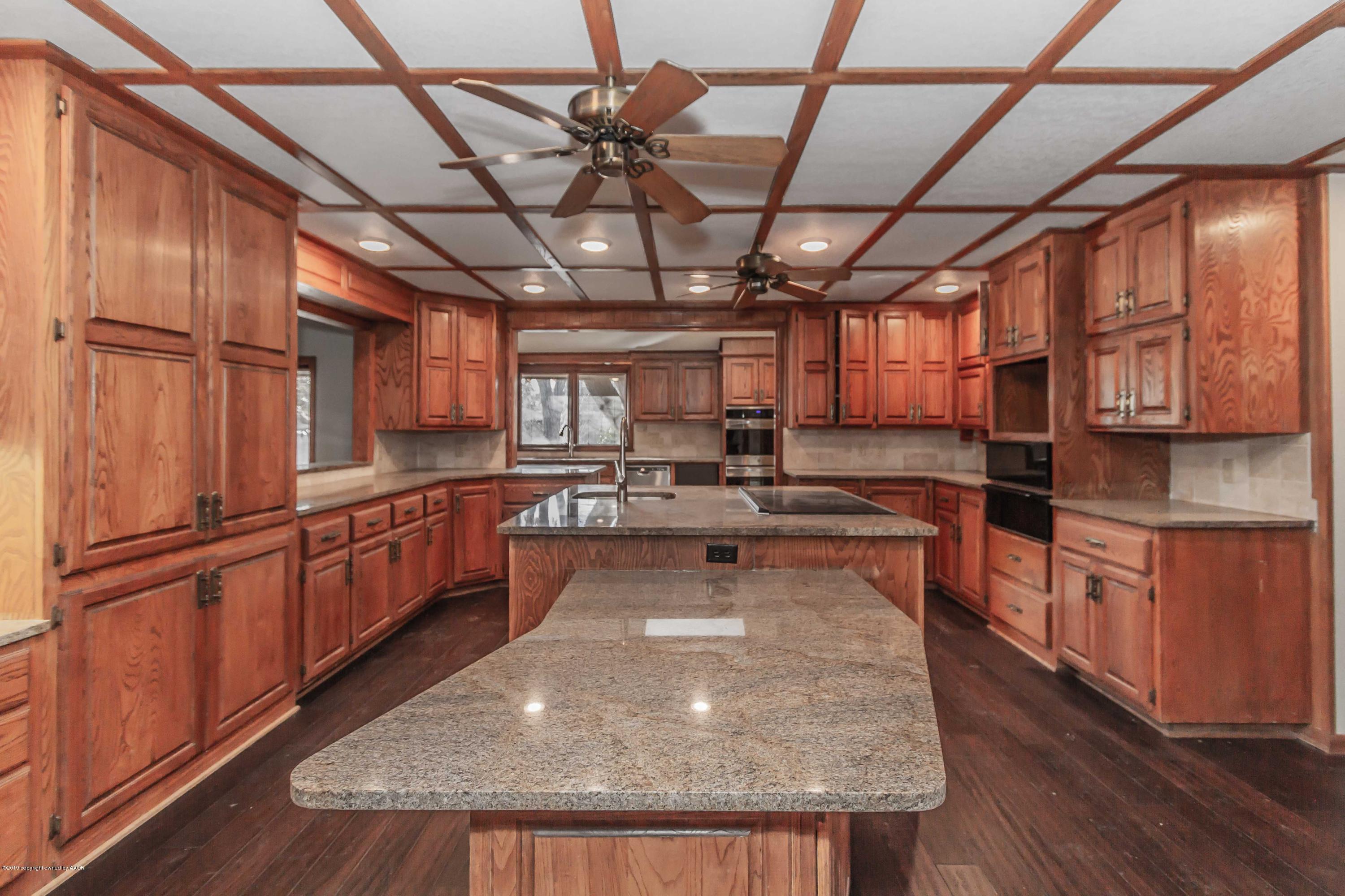 6801 Green Haven Road Amarillo, TX 79110 - Photo 6 of 65 a kitchen with stainless steel appliances granite countertop a sink a stove cabinets counter space and wooden floor