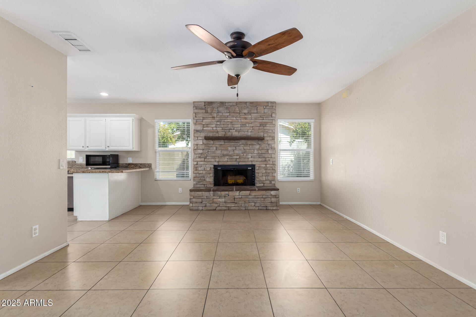 7412 East Ed Rice Avenue Mesa, AZ 85208 - Photo 13 of 36 a living room with a fireplace furniture a ceiling fan and a window