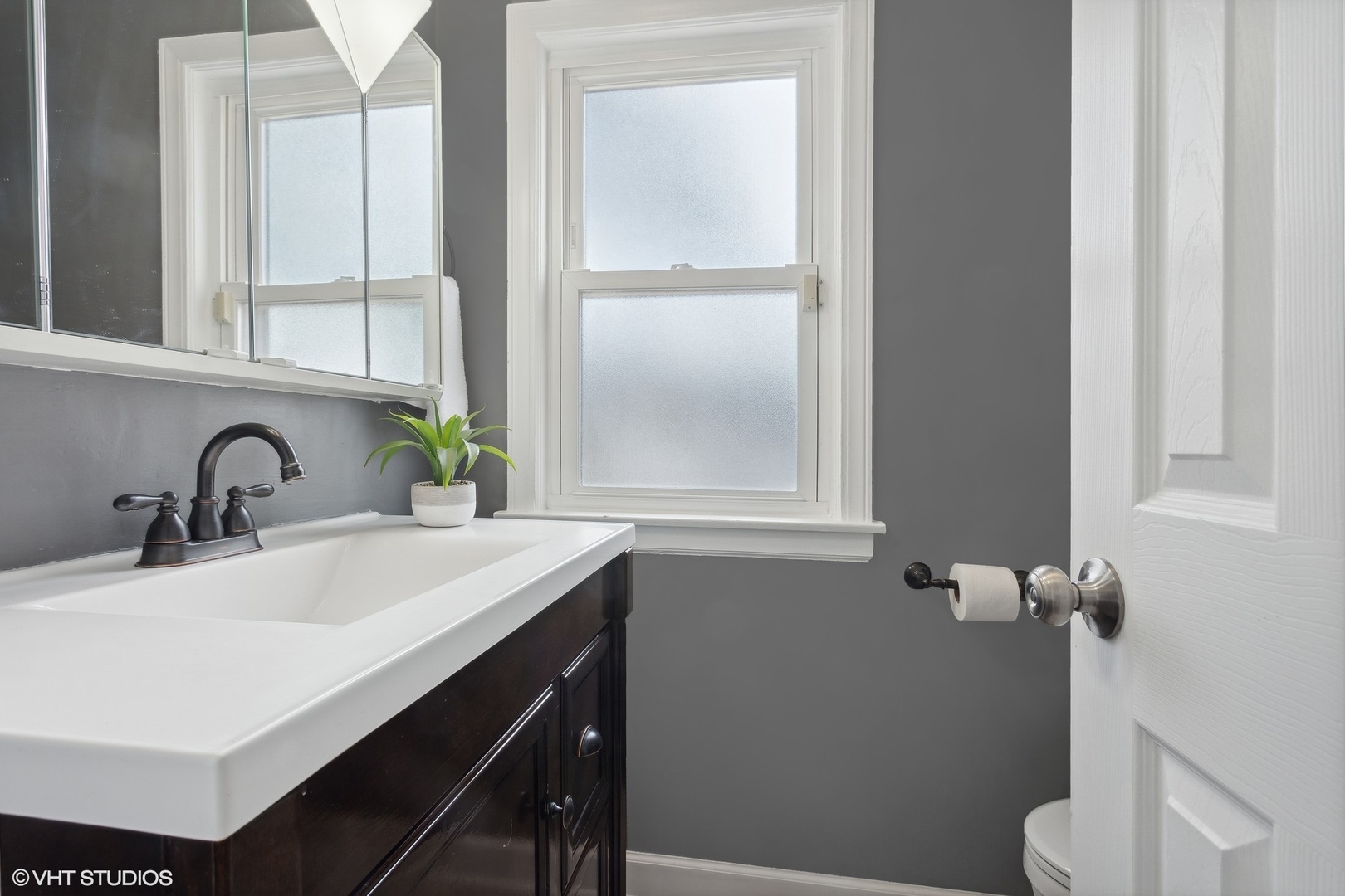 8501 Harding Avenue Skokie, IL 60076 - Photo 15 of 37 a bathroom with a sink a toilet and a window