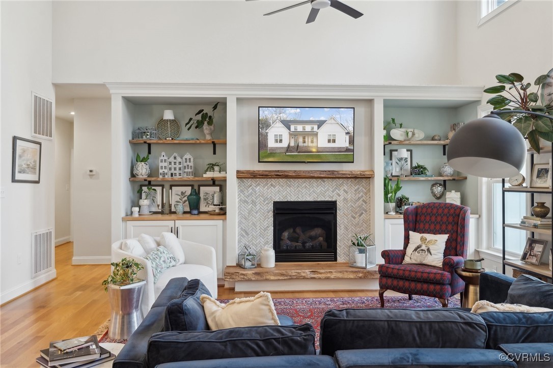 Living room with visible vents, ceiling fan, a til
