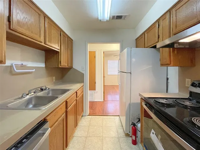 a kitchen with stainless steel appliances granite countertop a sink stove and refrigerator