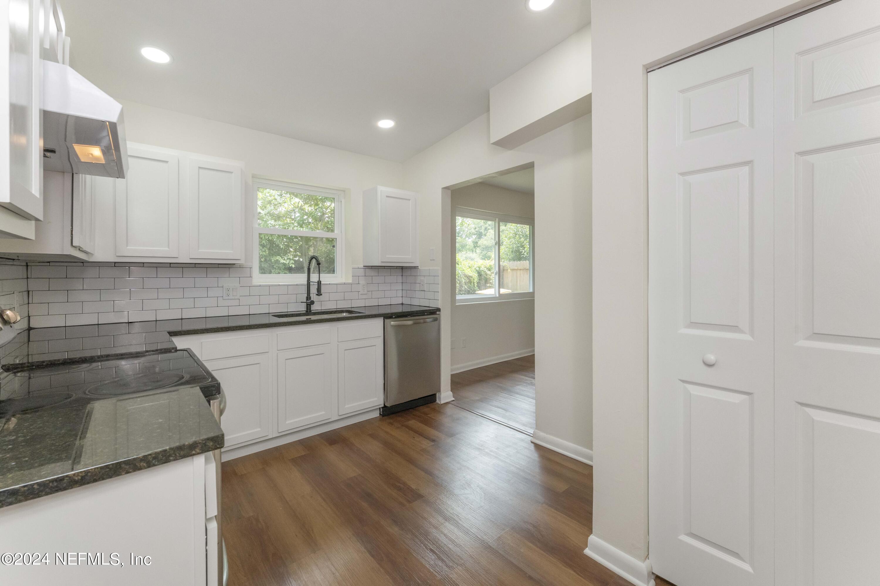 6937 Rollo Road Jacksonville, FL 32205 - Photo 12 of 26 a kitchen with granite countertop a sink and a stove top oven