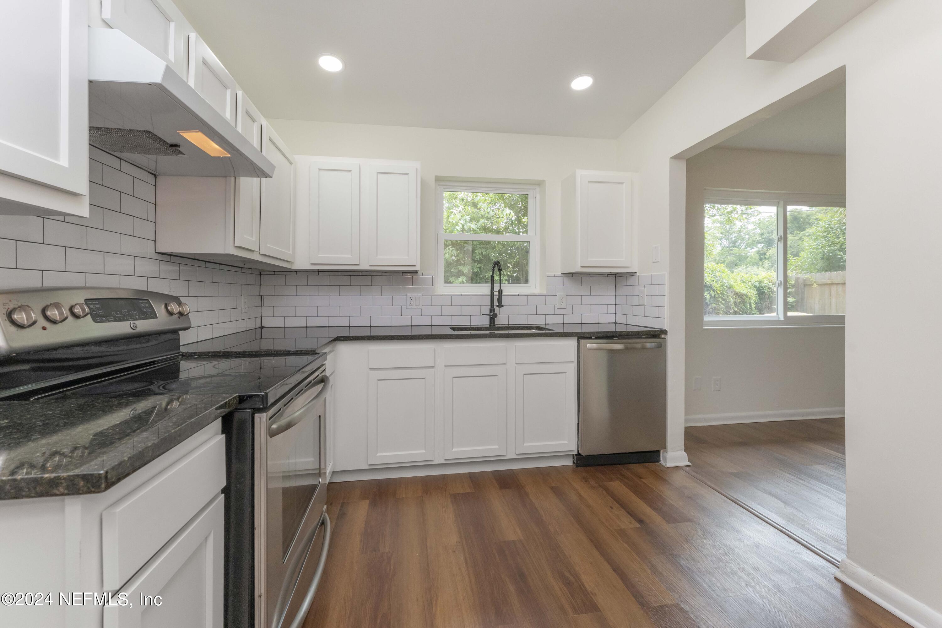 6937 Rollo Road Jacksonville, FL 32205 - Photo 13 of 26 a kitchen with a sink window and cabinets