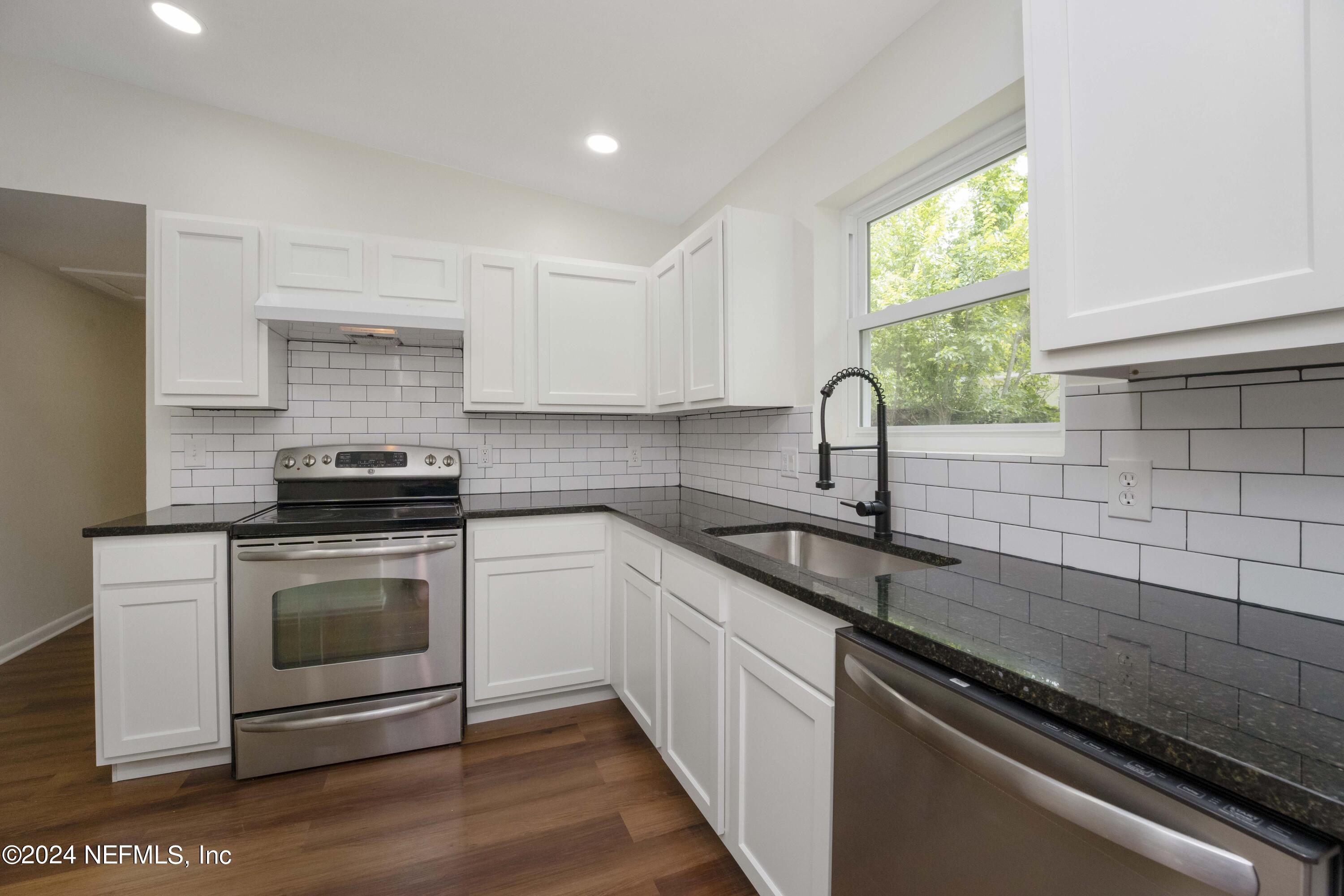 6937 Rollo Road Jacksonville, FL 32205 - Photo 14 of 26 a kitchen with a sink stove and cabinets