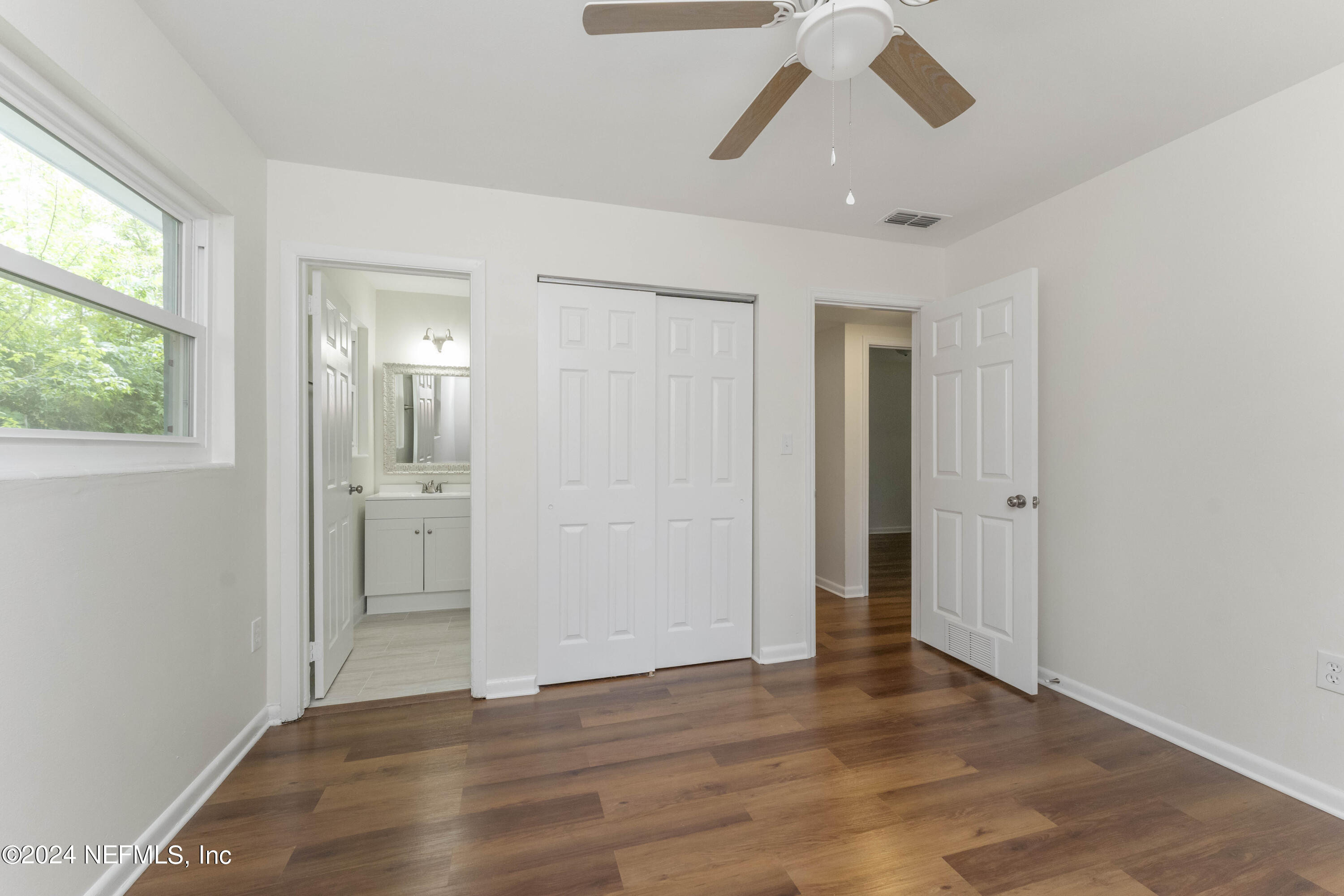 6937 Rollo Road Jacksonville, FL 32205 - Photo 16 of 26 wooden floor in an empty room with a window