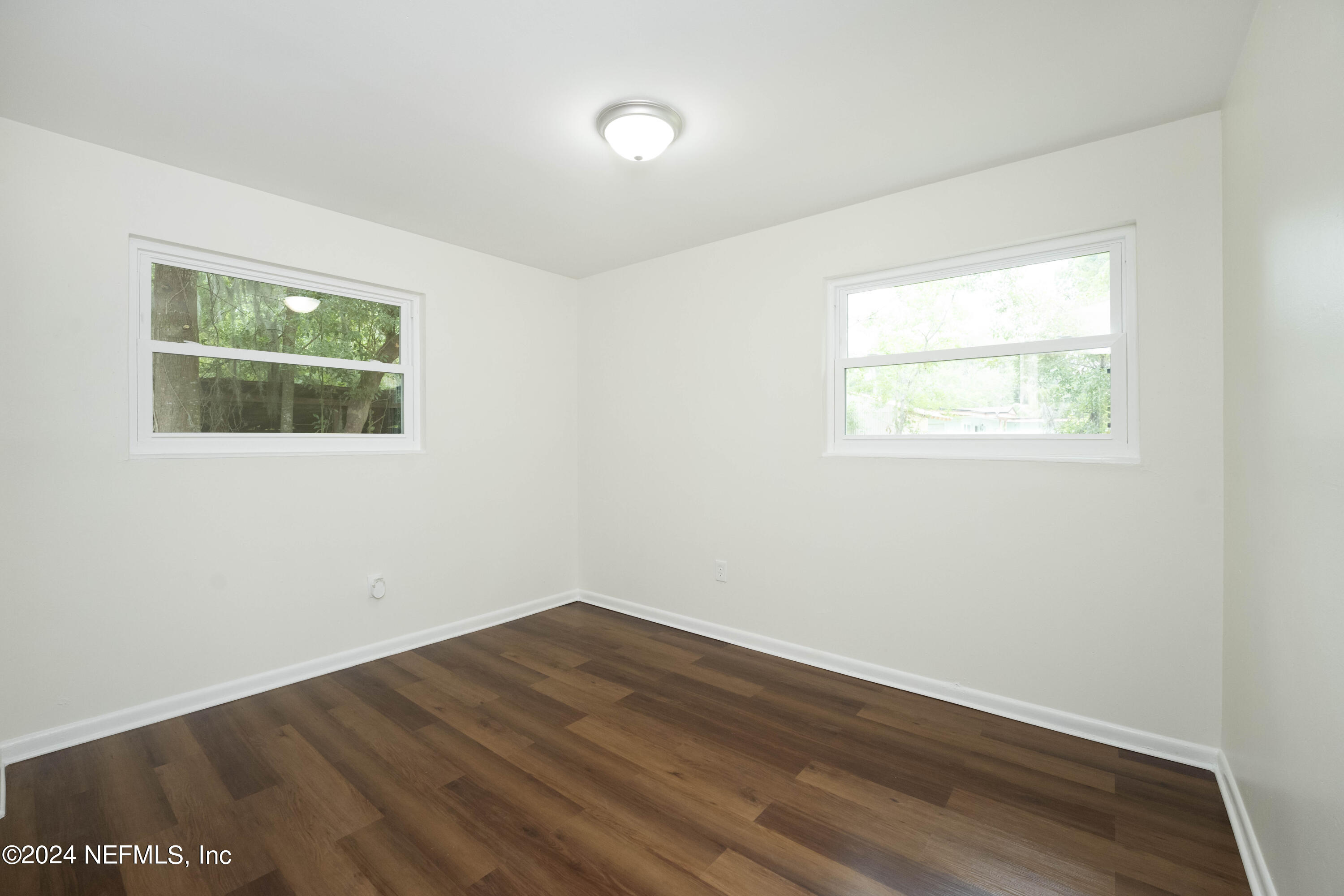 6937 Rollo Road Jacksonville, FL 32205 - Photo 19 of 26 an empty room with wooden floor and windows