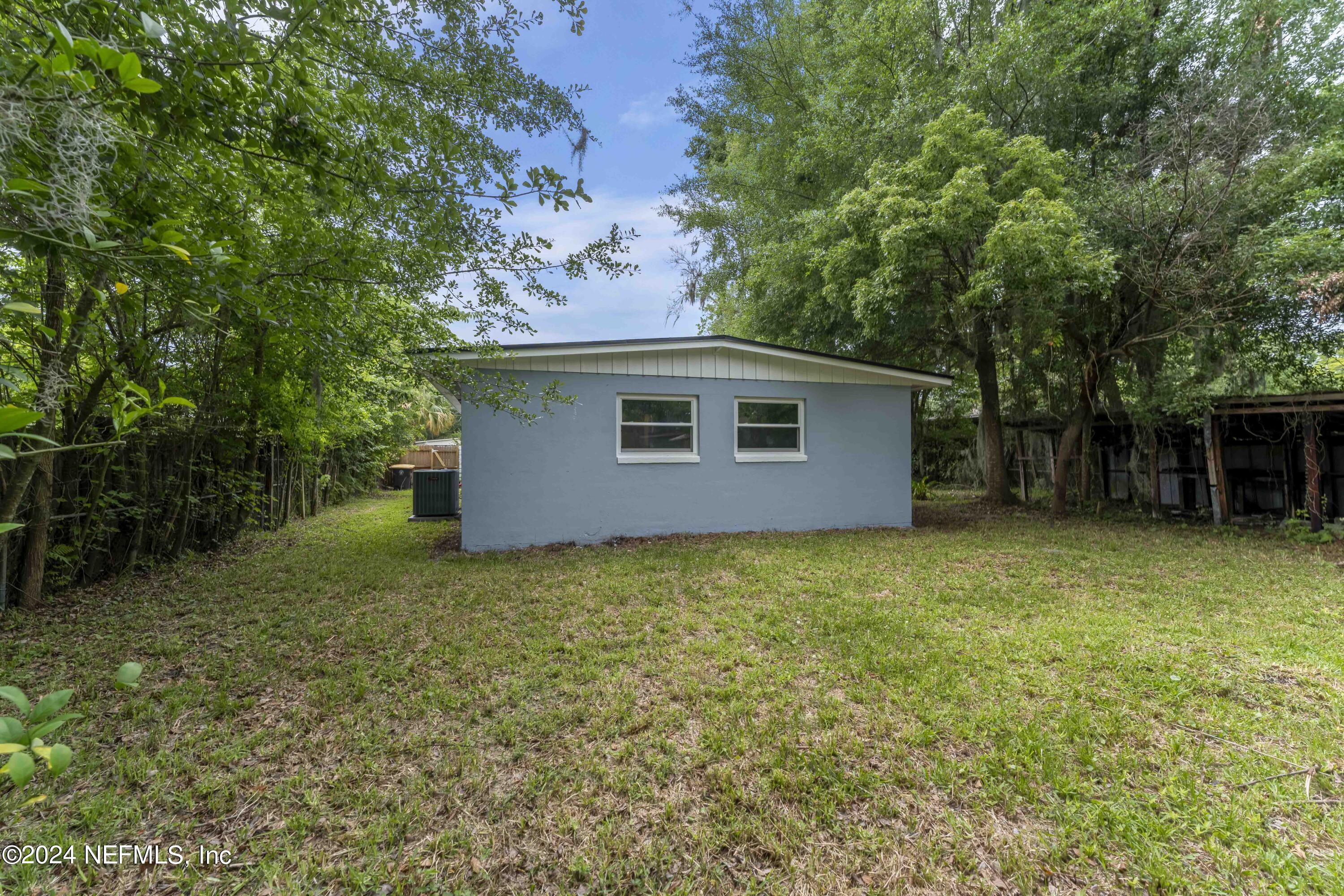 6937 Rollo Road Jacksonville, FL 32205 - Photo 24 of 26 a backyard of a house with plants and large tree