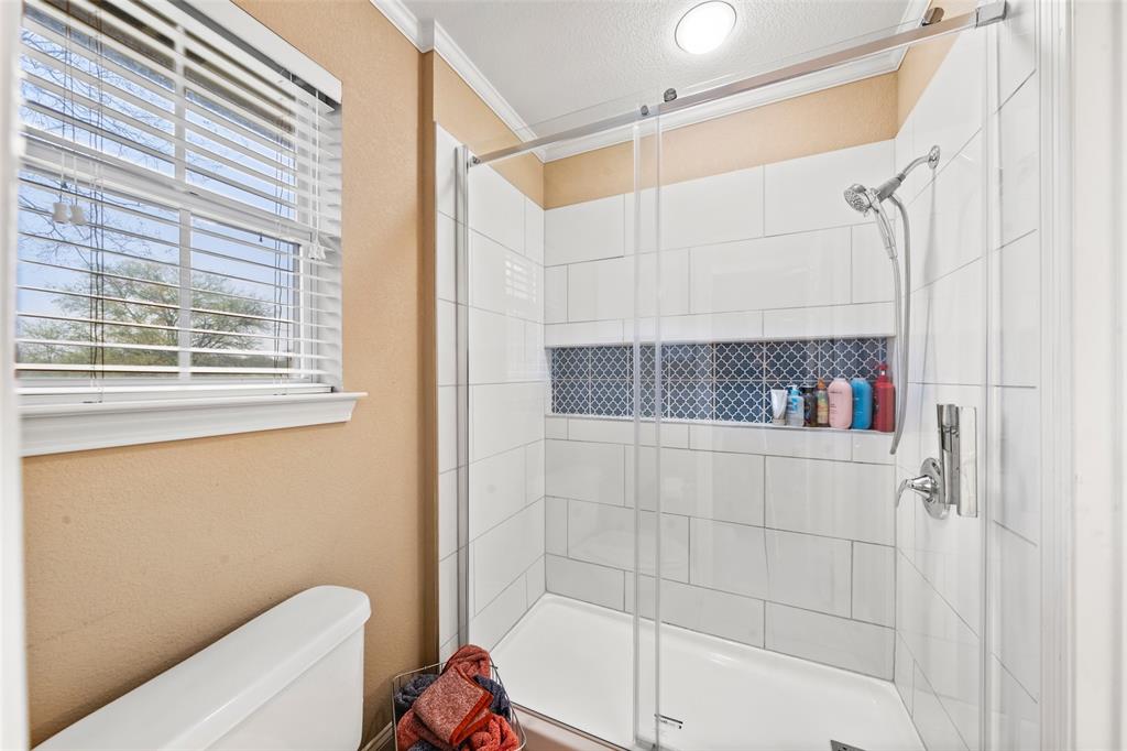 517 Chado Lane Robinson, TX 76706 - Photo 27 of 40 Bathroom #2 with crown molding, a shower stall, and a textured ceiling