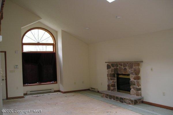 21 Old Timber Road Mount Pocono, PA 18344 - Photo 3 of 8 an empty room with a fireplace and windows