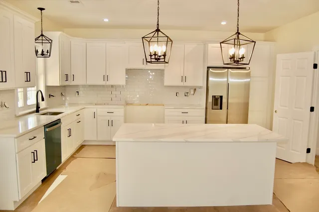 a kitchen with lot of cabinets and refrigerator