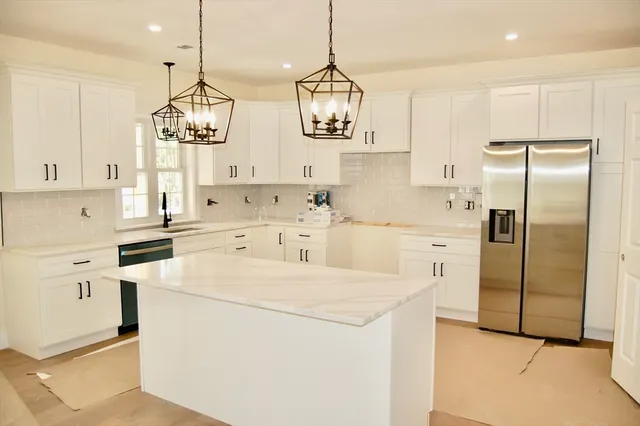 a kitchen with granite countertop white cabinets and a stove