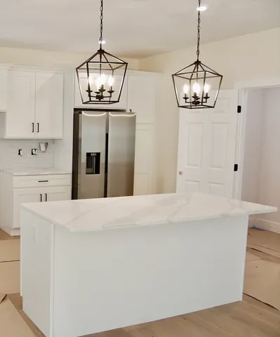 a kitchen with stainless steel appliances a stove a sink and white cabinets