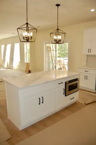 a kitchen with stainless steel appliances a stove and white cabinets