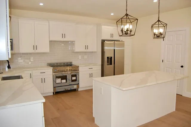 a kitchen with stainless steel appliances a refrigerator sink and stove top oven