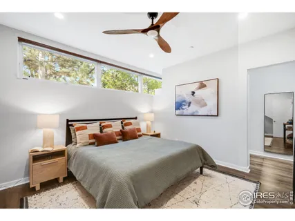 a bedroom with a bed and a painting on the wall