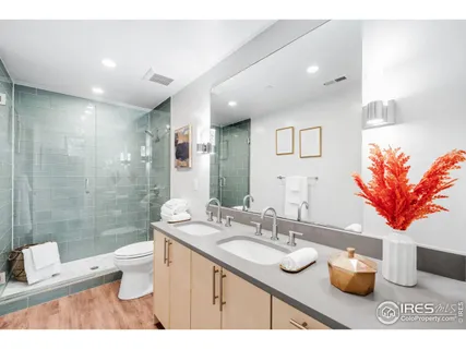 a bathroom with a granite countertop sink a toilet a mirror and shower
