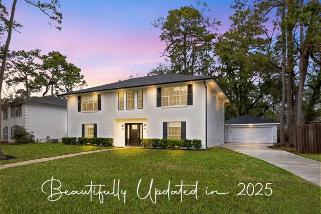 a view of a white house with a big yard
