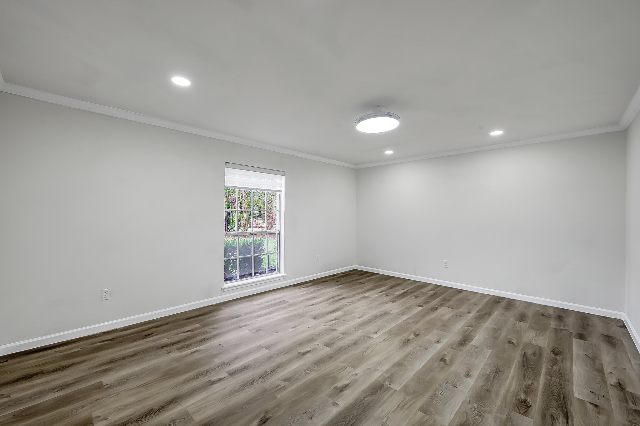 7610 Theisswood Road Spring, TX 77379 - Photo 16 of 42 a view of an empty room with wooden floor and a window