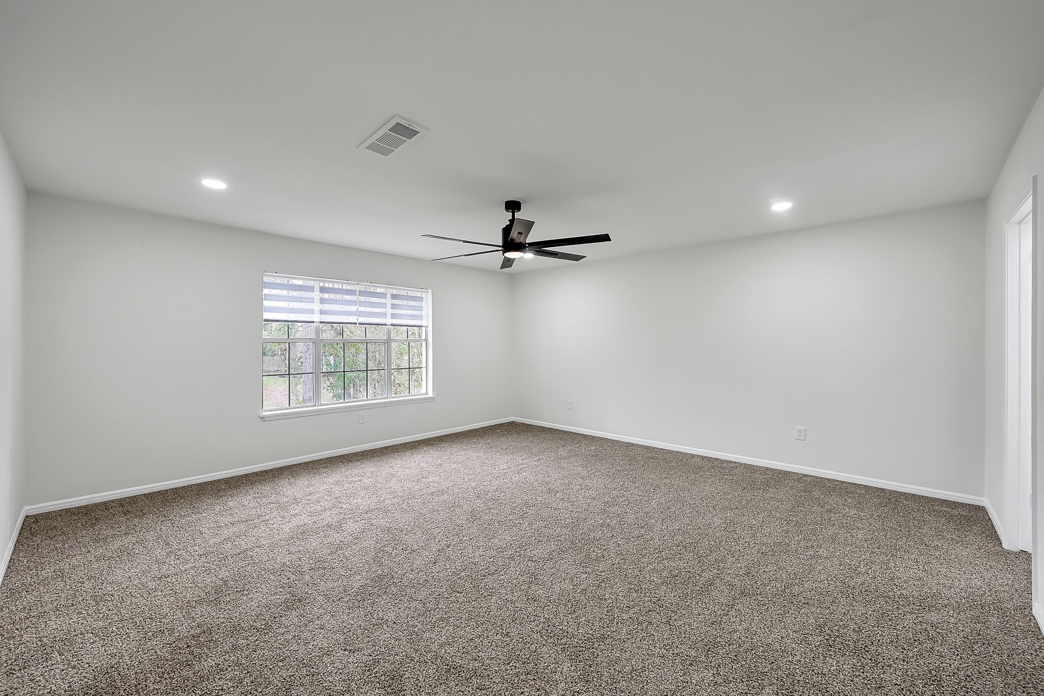7610 Theisswood Road Spring, TX 77379 - Photo 20 of 42 an empty room with windows and ceiling fan view