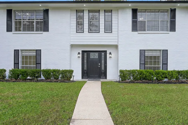 a front view of a brick house with a yard