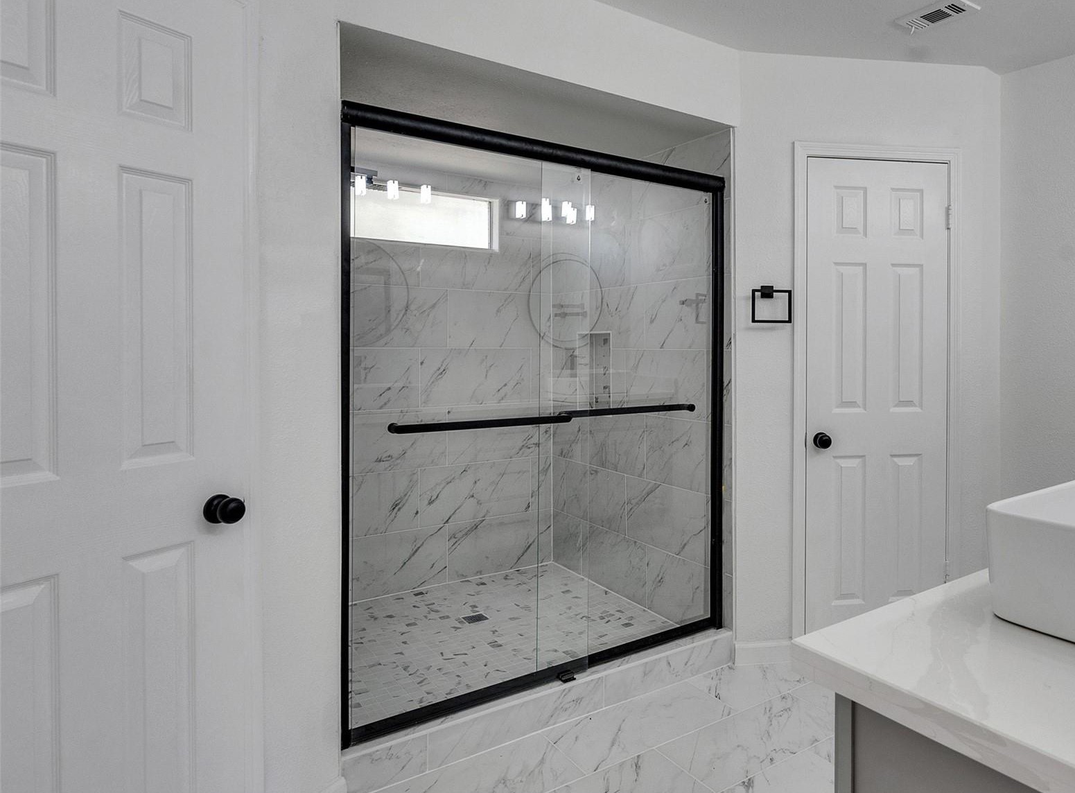7610 Theisswood Road Spring, TX 77379 - Photo 23 of 42 a bathroom with a glass shower door