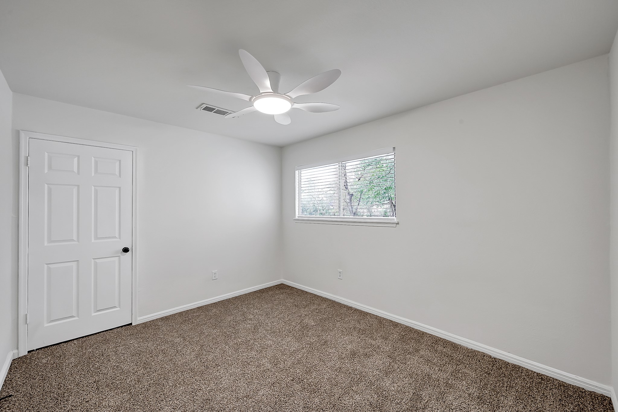 7610 Theisswood Road Spring, TX 77379 - Photo 26 of 42 an empty room with a window and a ceiling fan