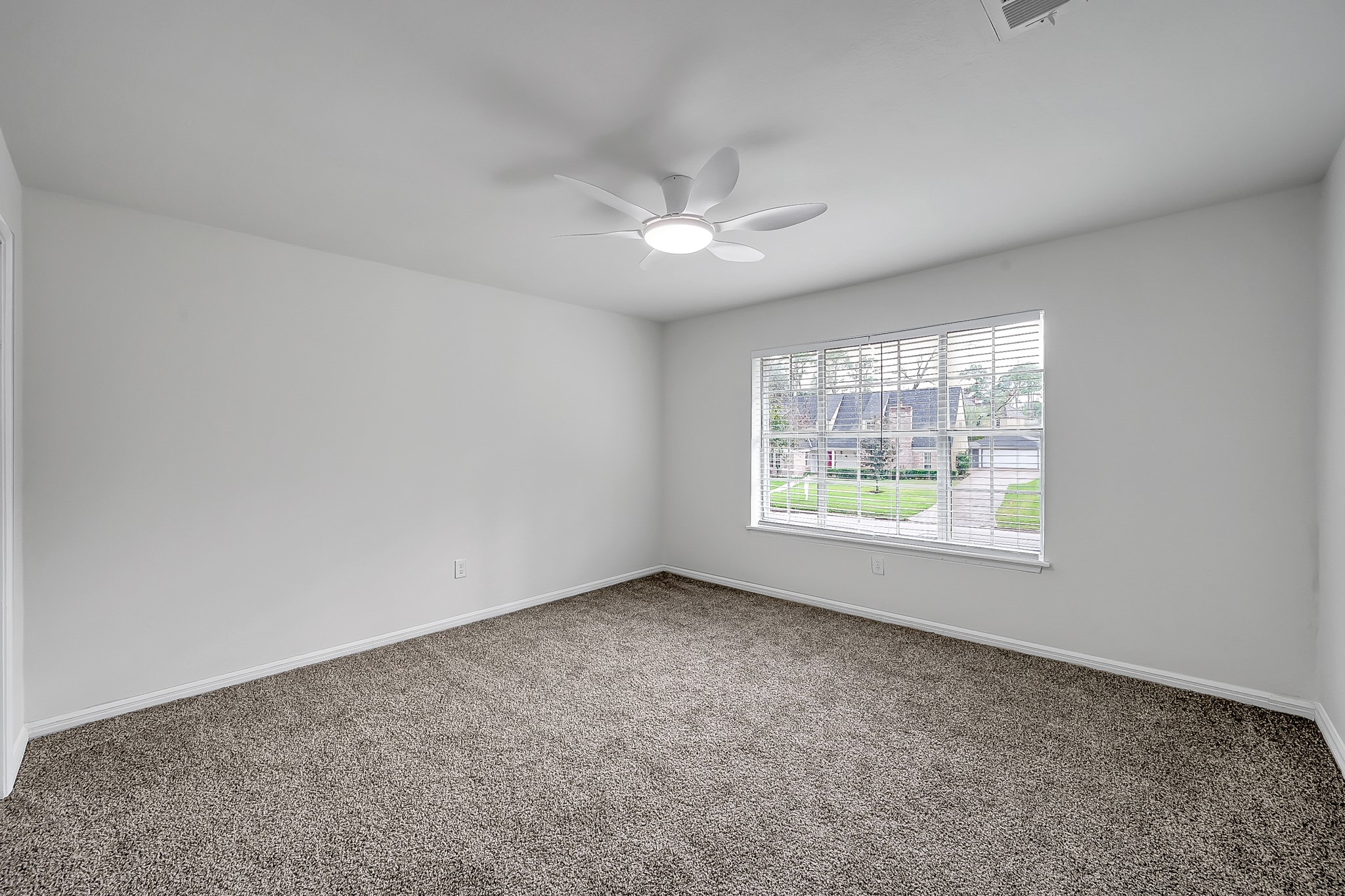 7610 Theisswood Road Spring, TX 77379 - Photo 28 of 42 an empty room with a window and a fan