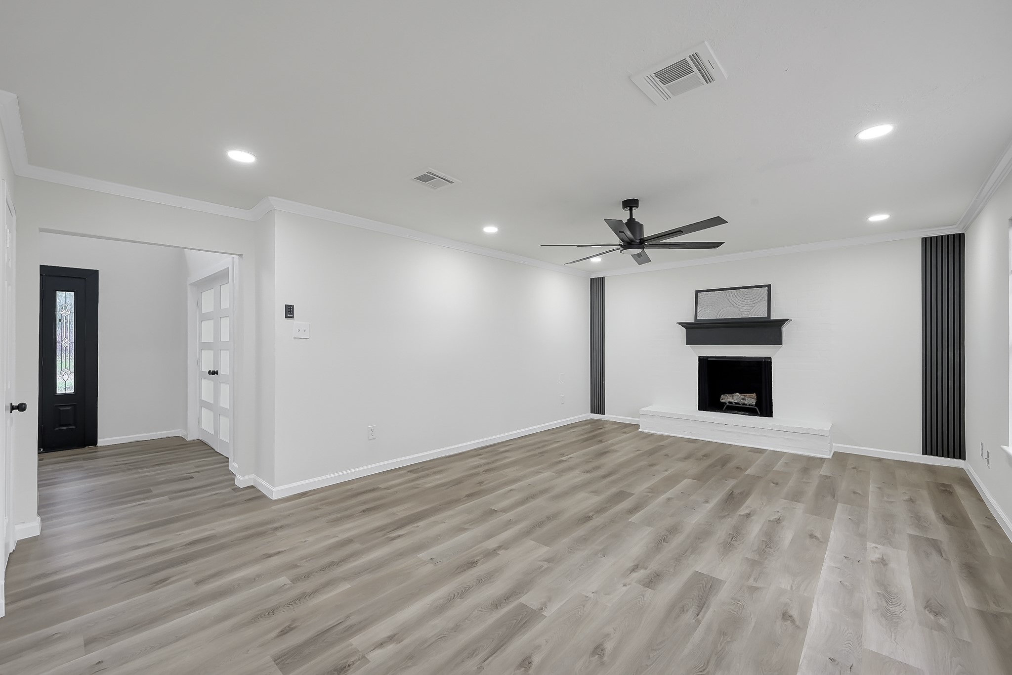 7610 Theisswood Road Spring, TX 77379 - Photo 3 of 42 a view of a livingroom with a fireplace a ceiling fan and wooden floor