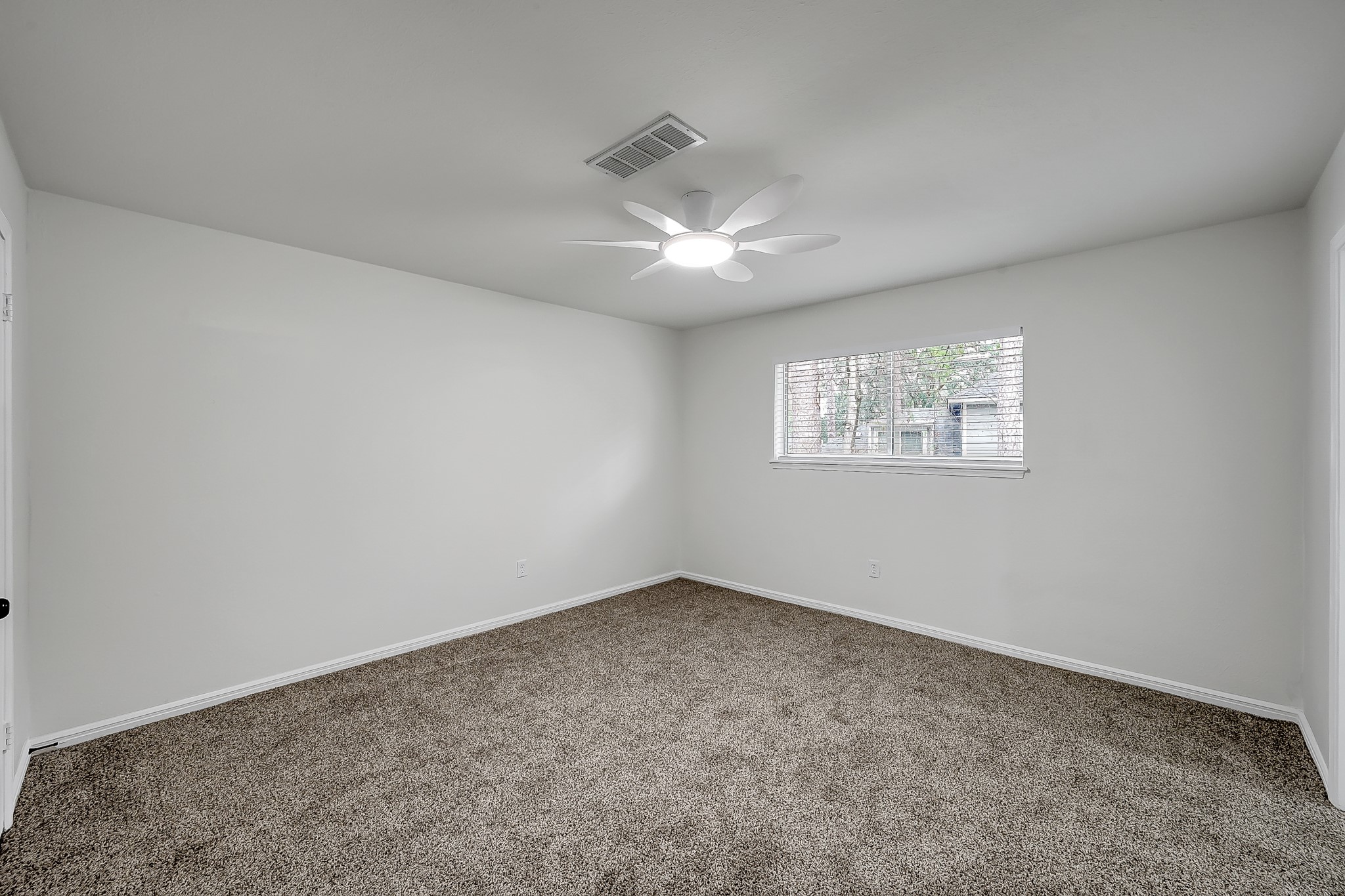 7610 Theisswood Road Spring, TX 77379 - Photo 32 of 42 an empty room with a fan & a window