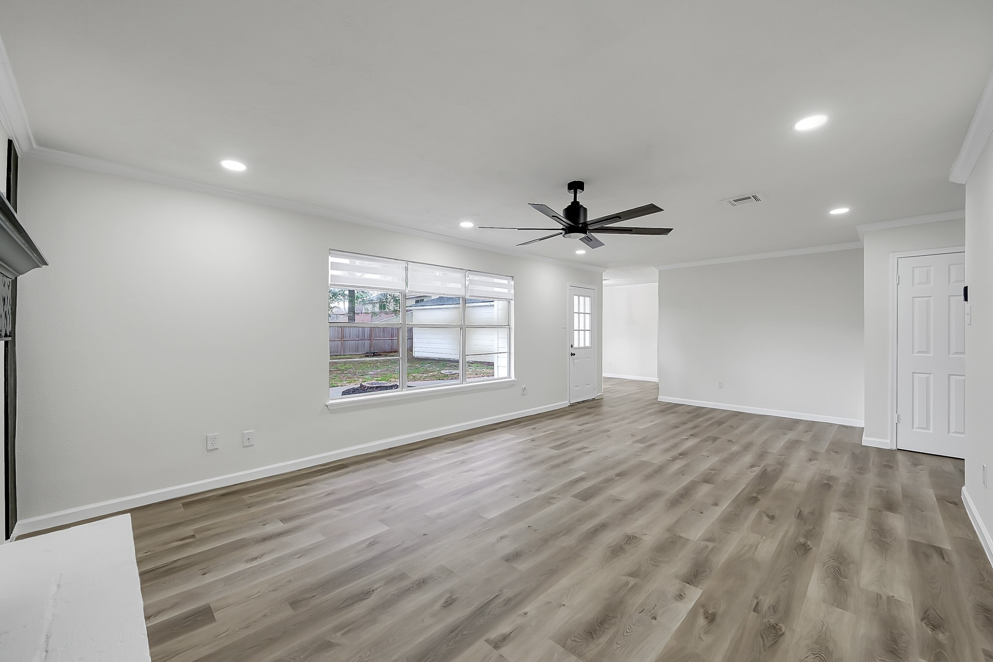 7610 Theisswood Road Spring, TX 77379 - Photo 5 of 42 an empty room with wooden floor fan and windows