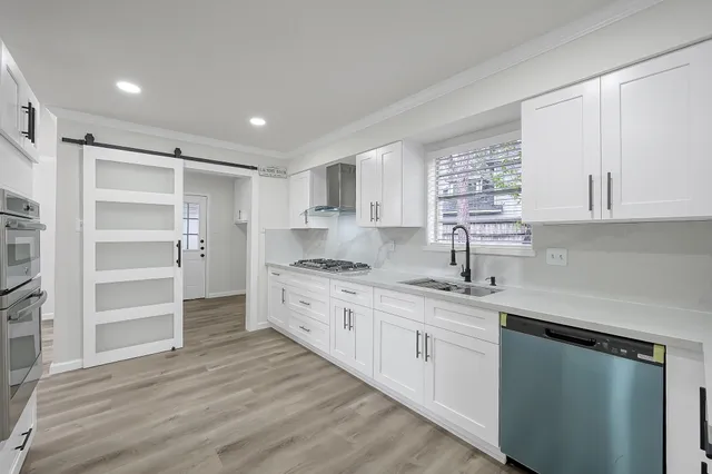 a kitchen with granite countertop cabinets stainless steel appliances and a wooden floor