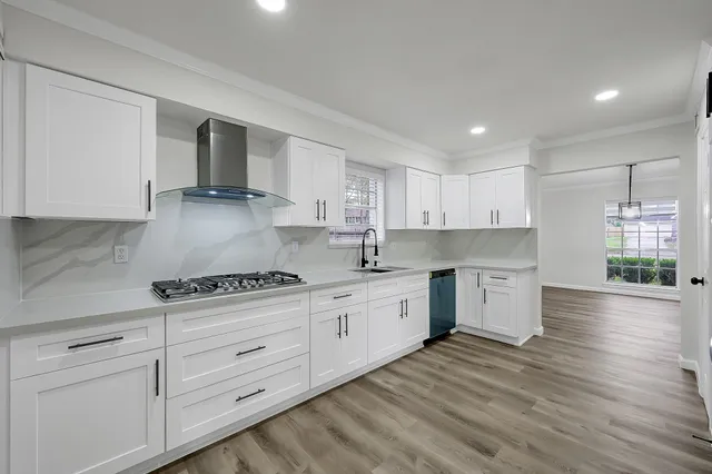a kitchen with stainless steel appliances a stove a microwave and white cabinets