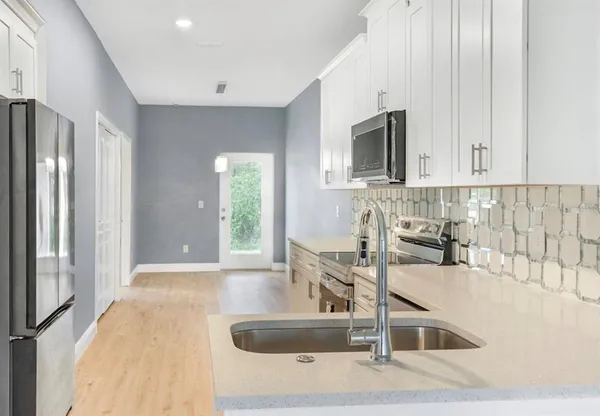 a kitchen with stainless steel appliances granite countertop a sink and a counter space