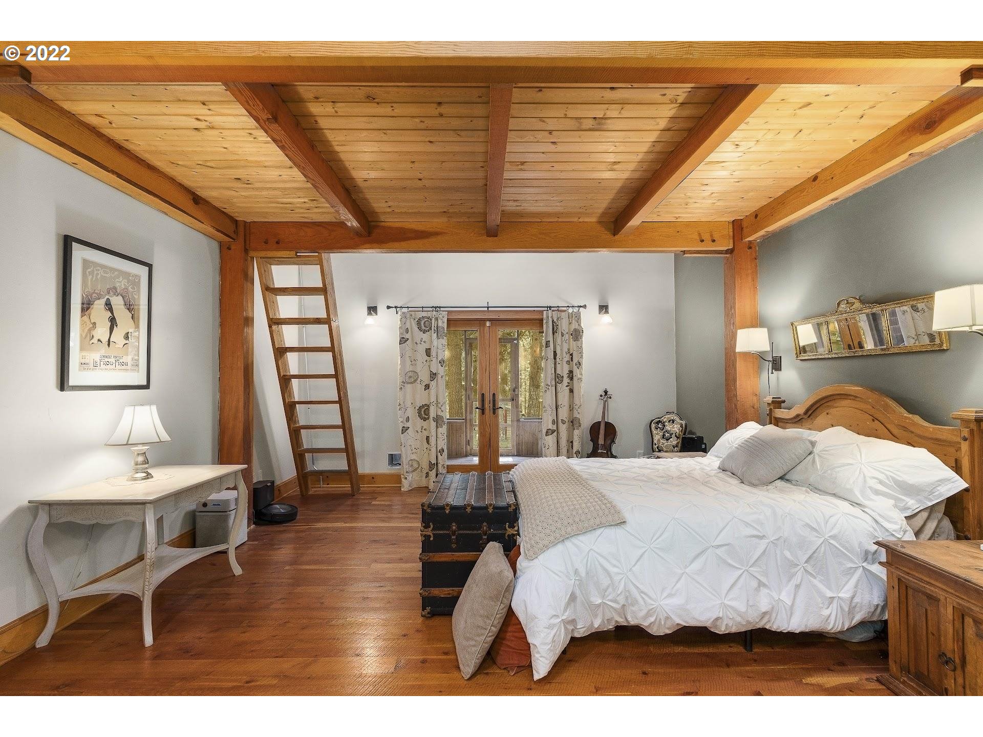 181 Lyons Road White Salmon, WA 98672 - Photo 11 of 32 a large bedroom with a bed a table and chair with the large mirror