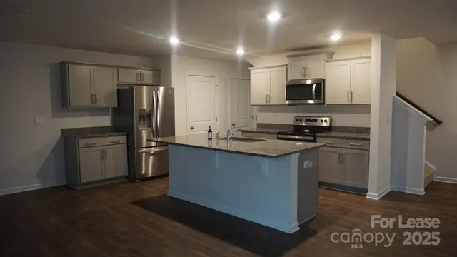 a kitchen with a refrigerator and a stove top oven