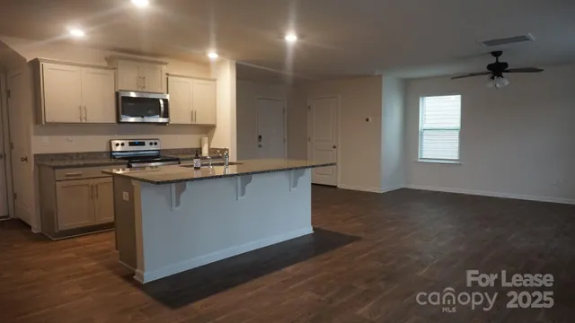 a kitchen with stainless steel appliances granite countertop a stove a sink and a microwave